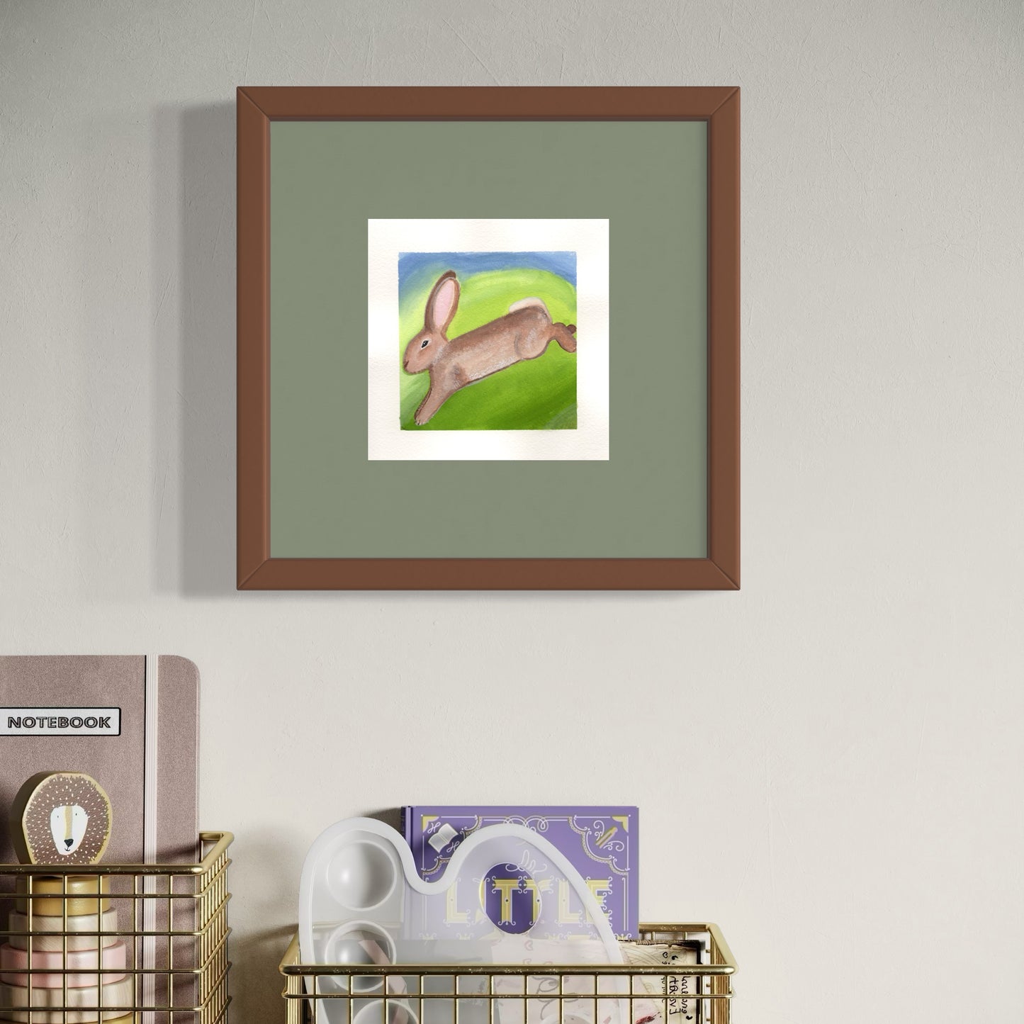 Framed artwork of a rabbit on a green background, displayed on a wall with books below.