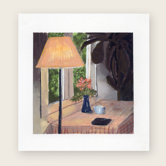 Kitchen table under a glowing lamp; warm light pools on the tabletop, background in soft shadow.