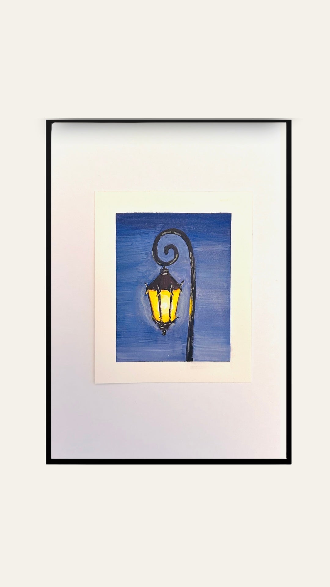 Framed artwork of a glowing street lamp lit against a blue sky.