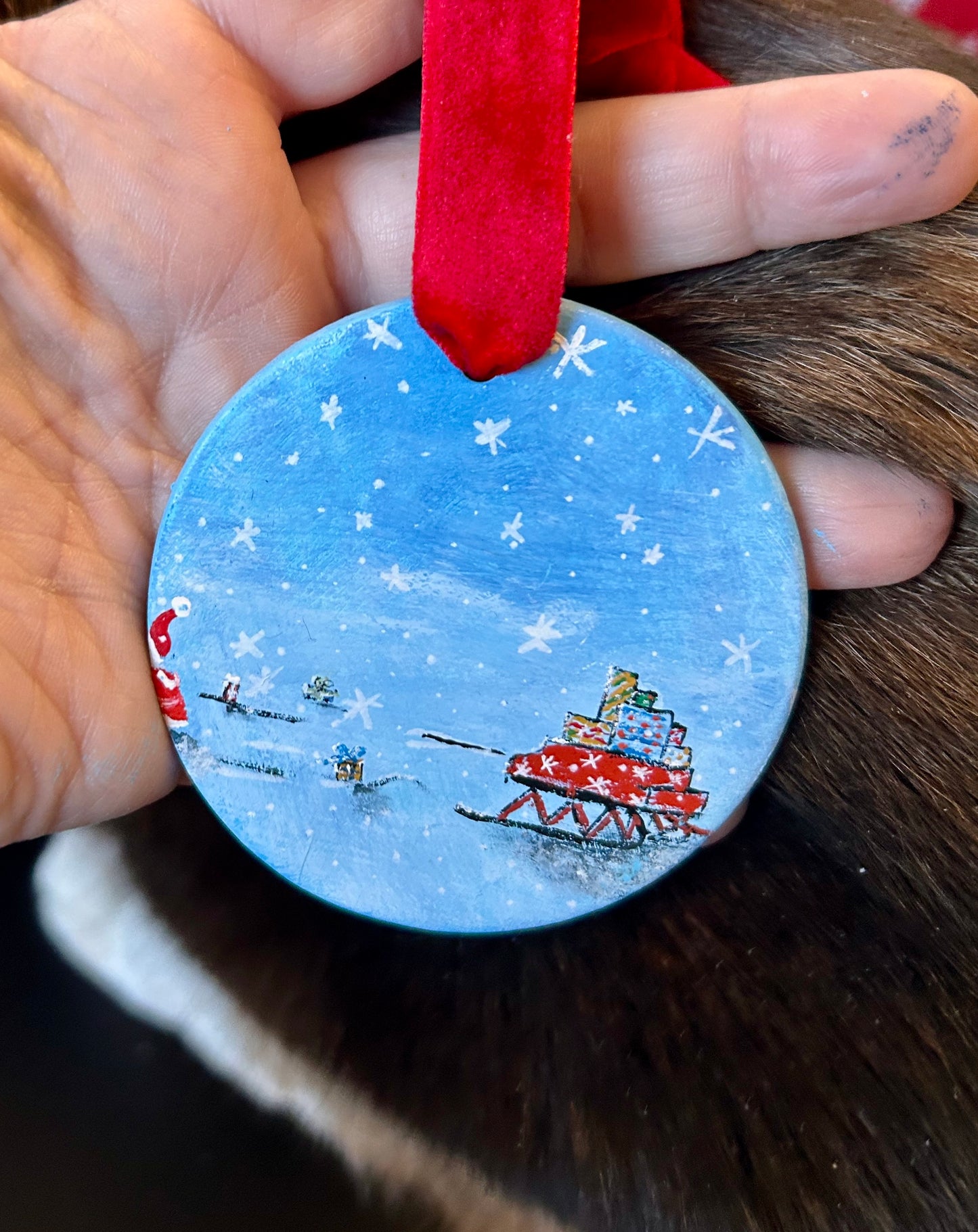 Original, hand-painted, round, flat Christmas ornament with a festive Santa's sleigh design.
